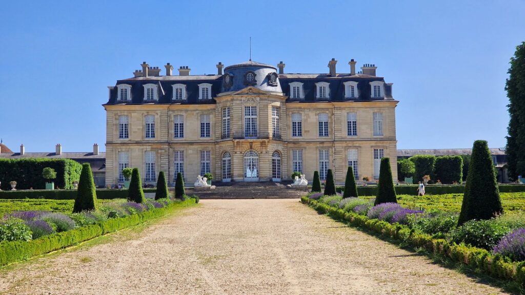 Grand French château with manicured formal gardens and warm limestone façade — the hallmark of a blush luxury venue in France