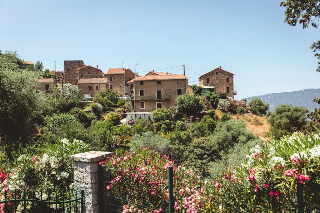 A Corsican hilltop stone village surrounded by lush gardens and pink oleanders, typical of the island's wedding estate settings