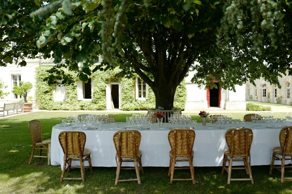An elegant outdoor wedding reception table set under a tree at a French estate