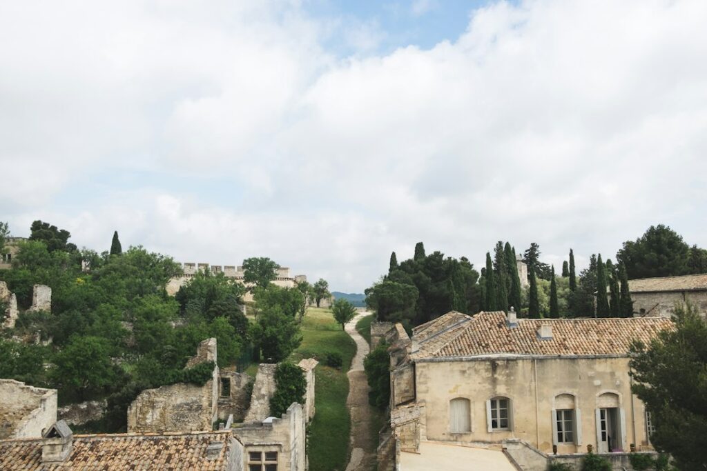 Aerial view of a Provence stone castle surrounded by cypress trees and lush green gardens in the Luberon region