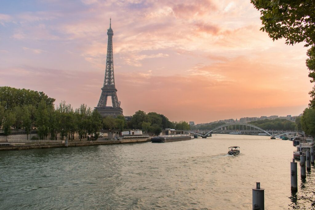 The Eiffel Tower glowing at sunset over the Seine river in Paris