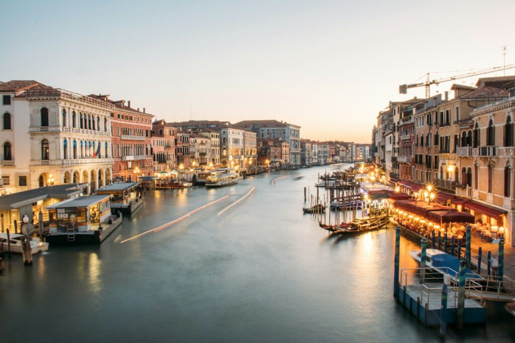 Venice Grand Canal at dusk with illuminated palazzi and boats reflected in the water